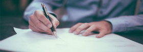 L'immagine mostra un uomo che sta firmando un contratto